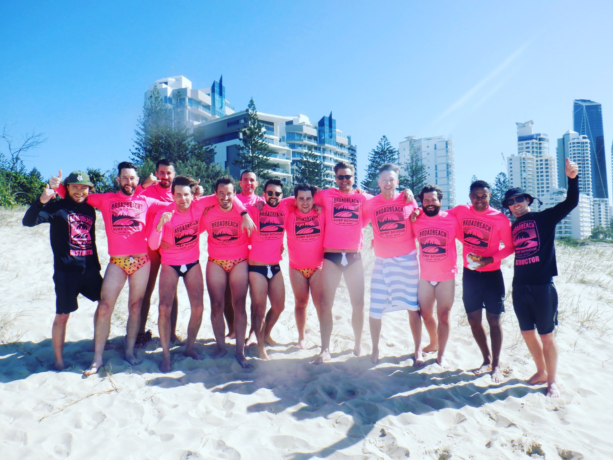 a group of people standing on a beach posing for the camera