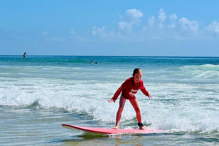 a girl riding a wave on a surfboard in the water