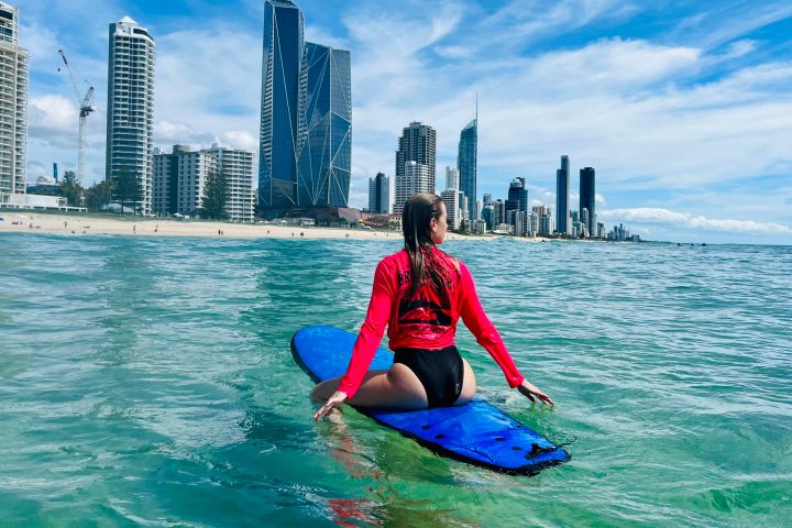 a young girl riding a wave on top of a body of water