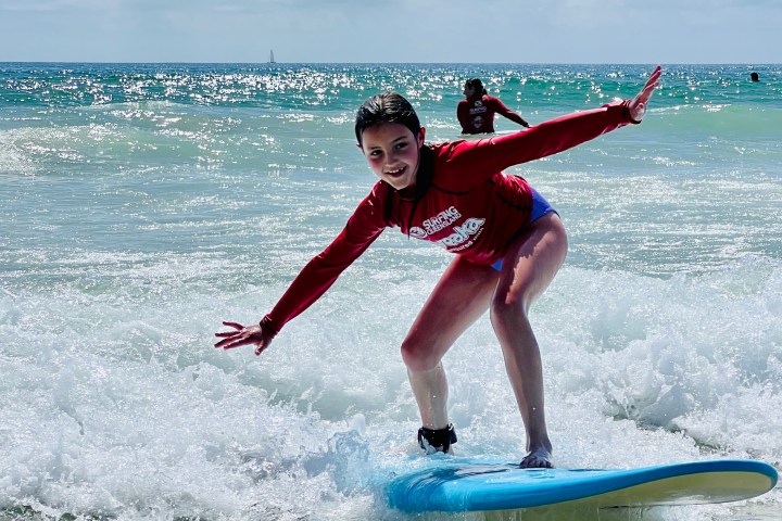 a girl riding a wave on a surfboard in the ocean