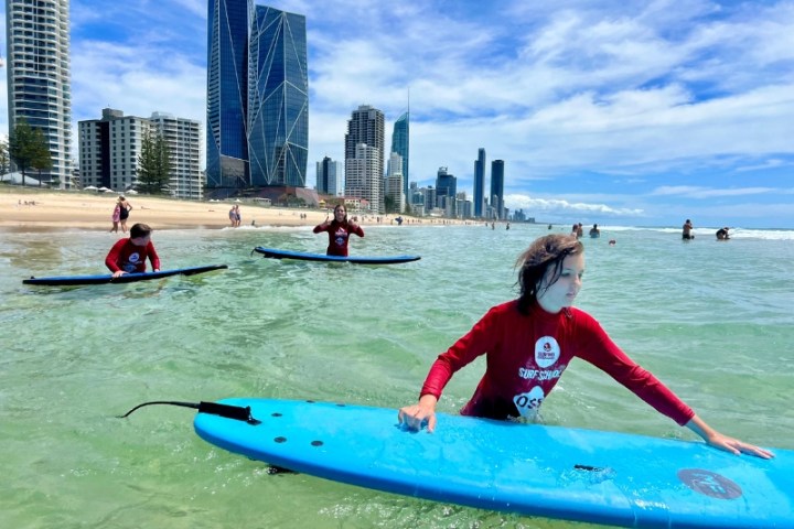 a young girl riding a wave on a surfboard in the water