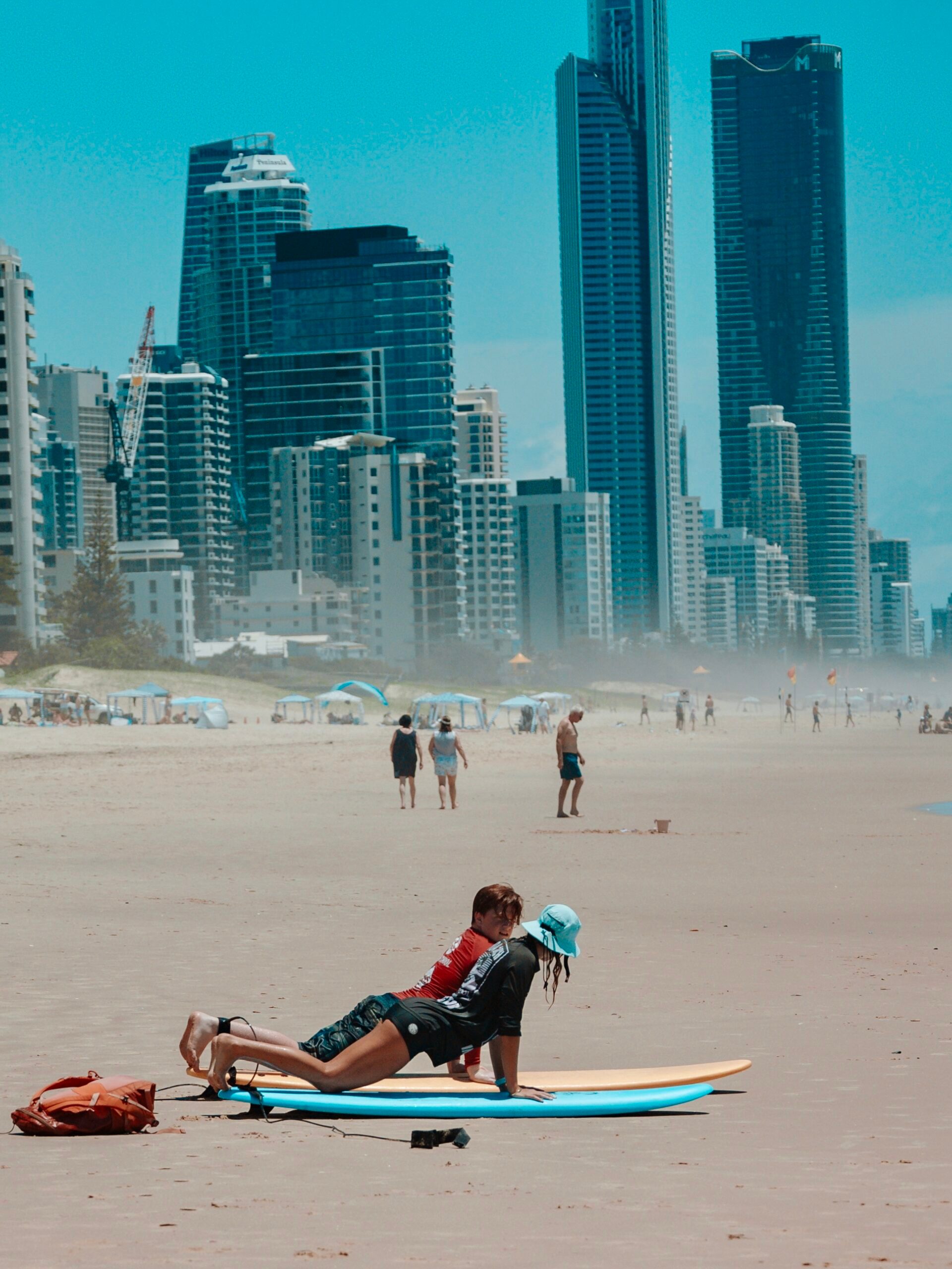 a group of people on a beach with a city in the background