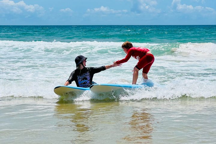 a man riding a wave on a surf board on a body of water