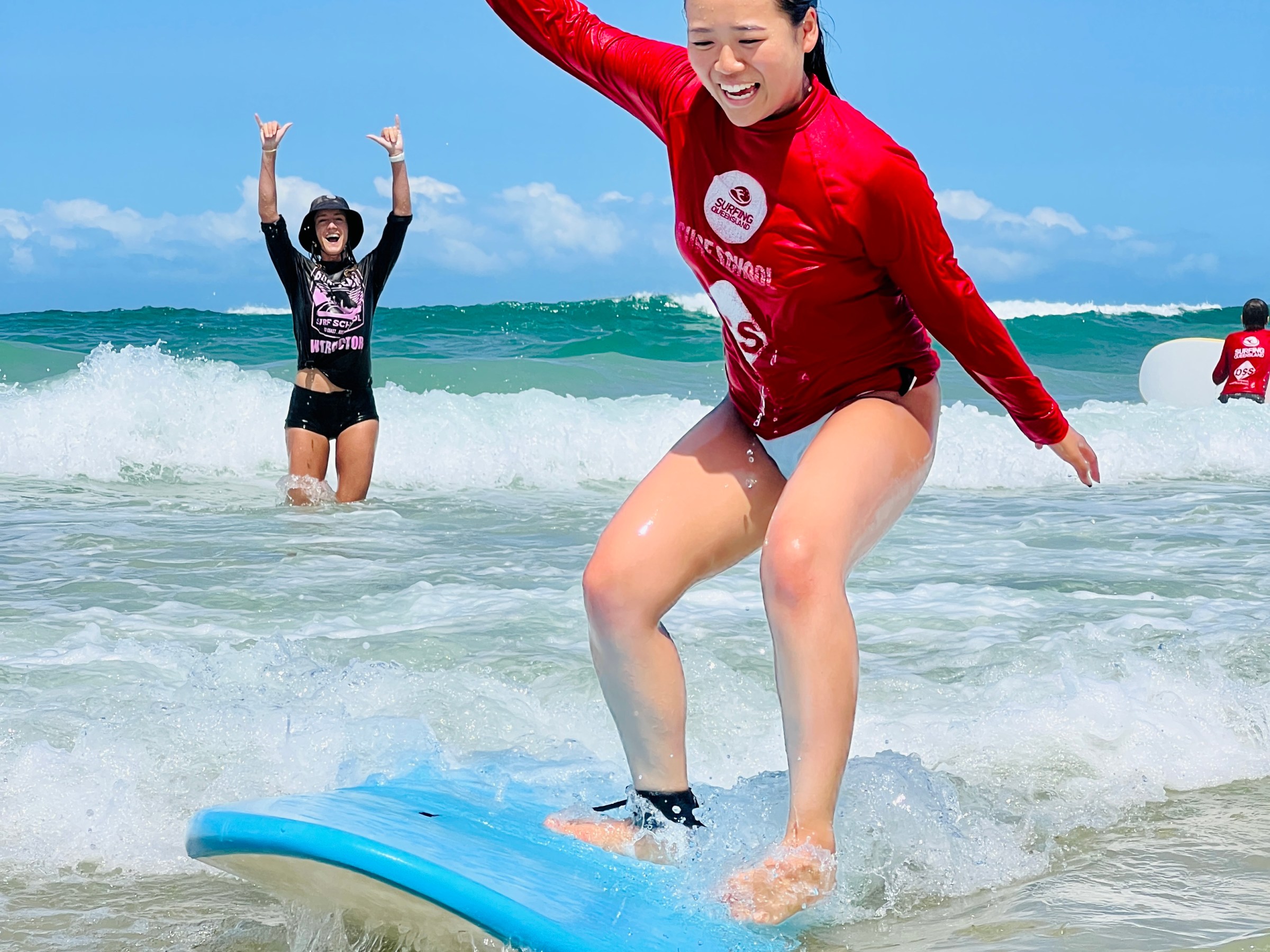 a young girl riding a wave on a surfboard in the water